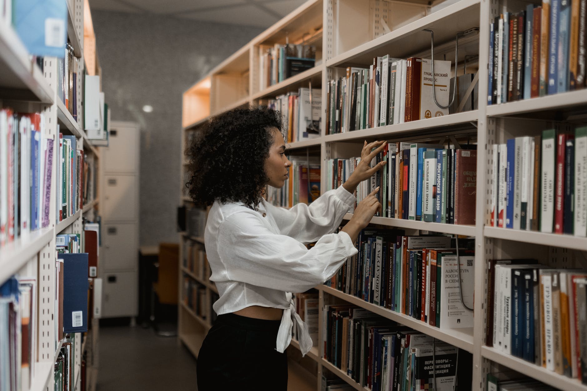 woman choosing a book from the shelves